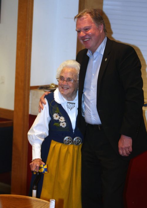 A bunch of Swedish people are at the Scandanavian Cultural Centre at 764 Erin St. Kirbyson story. (right) Karl-Erik Nilsson Swedish Football Association, President, gives Gunvor Larsson a honouring embrace. BORIS MINKEVICH/WINNIPEG FREE PRESS June 12, 2015