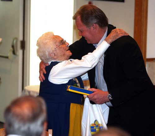 A bunch of Swedish people are at the Scandanavian Cultural Centre at 764 Erin St. Kirbyson story. (right) Karl-Erik Nilsson Swedish Football Association, President, gives Gunvor Larsson a honouring embrace. BORIS MINKEVICH/WINNIPEG FREE PRESS June 12, 2015