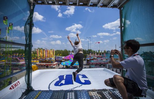 Matthew Cheung takes a picture as Aidan Geary tries out the Gravity Jump at the Red River Exhibition on opening day in Winnipeg on Friday, June 12, 2015.  The Gravity Jump is essentially a scaffolding tower from which you jump onto an airbag, and this is the first of it's kind in Canada. Mikaela MacKenzie / Winnipeg Free Press