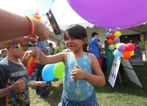 Six-year-old Kalissa  Redstar has her purple balloon tied to her wrist to keep it from blowing away while attending Pride Fest at the Forks with her family Saturday.  Standup photo   June 13, 2015 Ruth Bonneville / Winnipeg Free Press