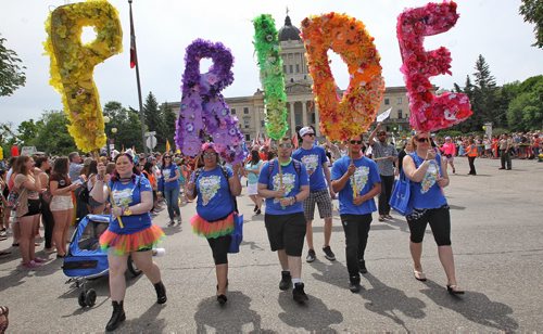 Participants in the Pride Parade walk along Memorial Blvd in front of the Manitoba Legislative Building carrying flower covered signs spelling out the word "Pride," Sunday afternoon.  150614 June 14, 2015 MIKE DEAL / WINNIPEG FREE PRESS