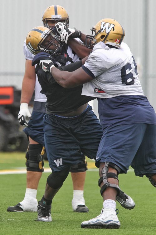 Nathaniel Collins (98) goes toe to toe with Chris Greaves (64) during Winnipeg Blue Bomber practice at the soccer pitch beside Investors Group Field Sunday morning.  150614 June 14, 2015 MIKE DEAL / WINNIPEG FREE PRESS