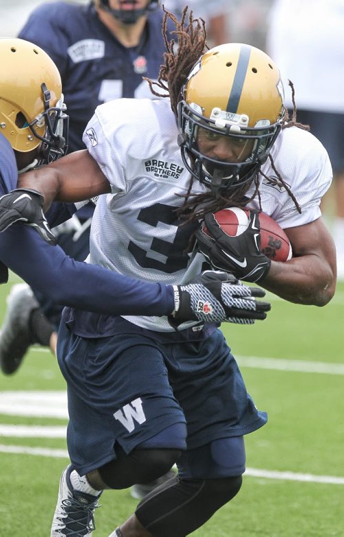 Paris Cotton (34) runs the ball during Winnipeg Blue Bomber practice at the soccer pitch beside Investors Group Field Sunday morning.  150614 June 14, 2015 MIKE DEAL / WINNIPEG FREE PRESS