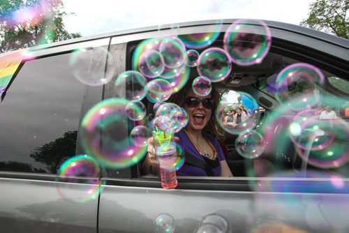 Tara Lambert shoots bubbles from the passenger seat of a vehicle taking part in the 28th Anniversary of the Winnipeg Pride Parade Sunday afternoon. 150614 - Sunday, June 14, 2015 -  MIKE DEAL / WINNIPEG FREE PRESS