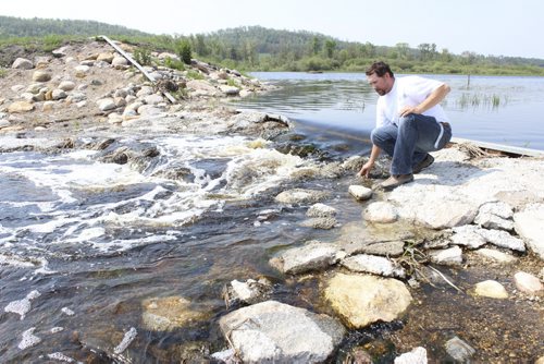 Justin Reid, manager of the LaSalle Redboine Conservation District, inspects the new dam at Pelly Lake that will eliminate 3.5 tonnes of phosphorus per year. BILL REDEKOP/WINNIPEG FREE PRESS June 8,¤ 2015