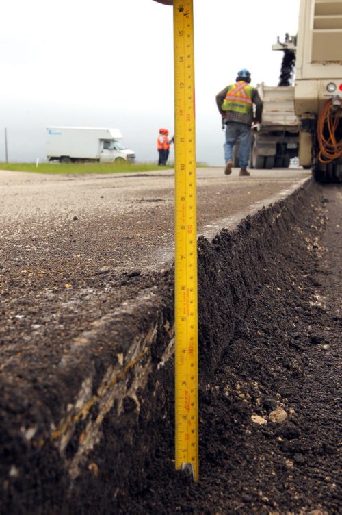 Ste. Agathe, MB.  Crews grind out the road there for reconstruction. Dan Lett feature on hwy 75 construction - comparing canada/US.  Here they measure how deep they went.  BORIS MINKEVICH/WINNIPEG FREE PRESS June 25, 2014