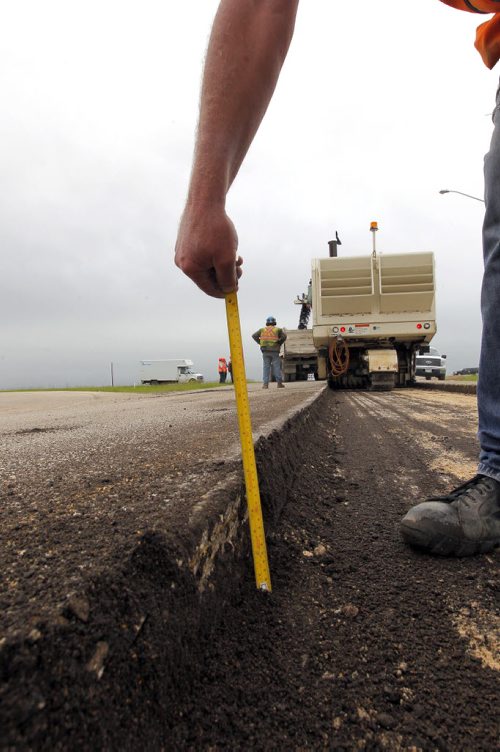 Ste. Agathe, MB.  Crews grind out the road there for reconstruction. Dan Lett feature on hwy 75 construction - comparing canada/US.  Here they measure how deep they went.  BORIS MINKEVICH/WINNIPEG FREE PRESS June 25, 2014