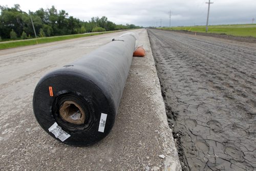 Ste. Agathe, MB.  After the shoulder is packed down a special cloth is put down to help stop damage. Dan Lett feature on hwy 75 construction - comparing canada/US.  Here is one of the rolls on the side of the crumbling road. BORIS MINKEVICH/WINNIPEG FREE PRESS June 25, 2014