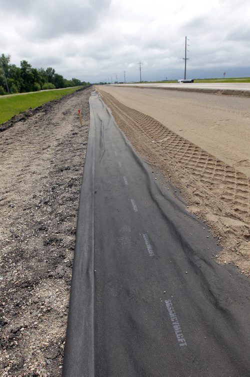 Ste. Agathe, MB.  After the shoulder is packed down a special cloth is put down to help stop damage. Dan Lett feature on hwy 75 construction - comparing canada/US.  Here the special cloth shown under the hard pack shoulder. BORIS MINKEVICH/WINNIPEG FREE PRESS June 25, 2014