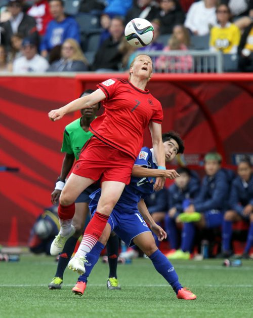 Germany's #7 Melanie Behringer goes up for the header as Thailand 's #13 Orathai Spimanee looks up from underneath her opponent early in Monday's FIFA Match at Investors Field in Winnipeg. See story. June 15, 2015 - (Phil Hossack / Winnipeg Free Press)