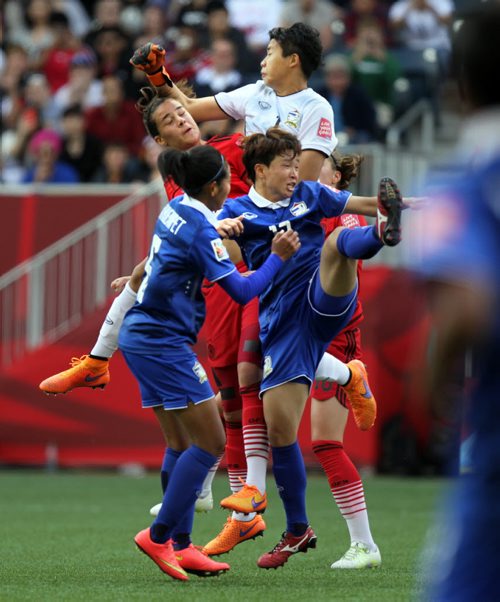 Thailand's netminder Waraporn Boonsing emergies on top of a cloud of flying players in front of his net looking for the save Monday at Investor's Field in FIFA Action. See Story. June 15, 2015 - (Phil Hossack / Winnipeg Free Press)