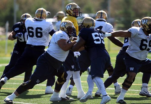SPORTS - CFL - WINNIPEG BLUE BOMBERS - General action shots of the o-line and d-line battling it out on the field.  Drew WIlly in the yellow/middle. BORIS MINKEVICH/WINNIPEG FREE PRESS June 16, 2015