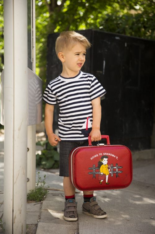 Eli Bebek, who is almost three, waits for the bus with a suitcase full of toys in the exchange district on Tuesday, June 16, 2015. Mikaela MacKenzie / Winnipeg Free Press