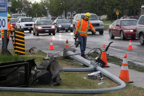 City of Winnipeg signals crews scramble to re-hook up a traffic light that was clipped by a semi trailer involved in a mva with a car Wednesday morning at Inkster Blvd and Sheppard St.- Traffic is disrupted to one lane on westbound Inkster as the mishap is fixed up- Breaking News- June 17, 2015   (JOE BRYKSA / WINNIPEG FREE PRESS)