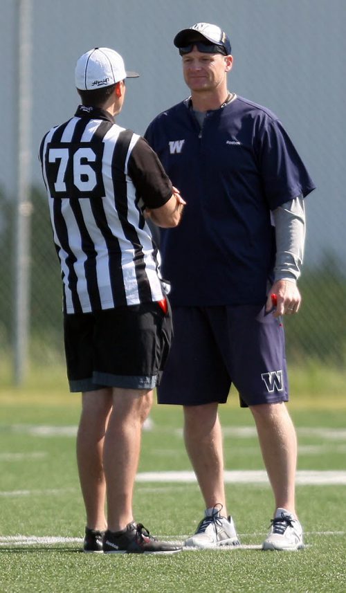 WINNIPEG BLUE BOMBER PRACTICE - Coach Mike O'Shea, right, talks to a ref that was at the practice. Refs come to practices as a resource for the team to learn and clarify any CFL rules. BORIS MINKEVICH/WINNIPEG FREE PRESS June 17, 2015