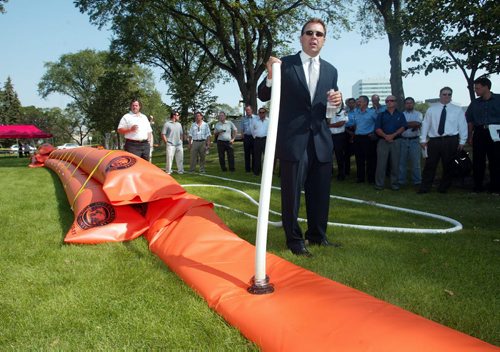 ken gigliotti / winnipeg free press /aug 19 2003  Paul Vickers  demonstrates  "Emergency Rapid  Deployment System"  an inflatable  tubes that can be  inflated , these 50 foot  x 19in water bags  weigh 60 lbs empty and 6100 lbs  full of water taking the place of500 sand bags  .- can be used by fire dept  for hazmat calls - at Leg demonstration- see Mia story-kg