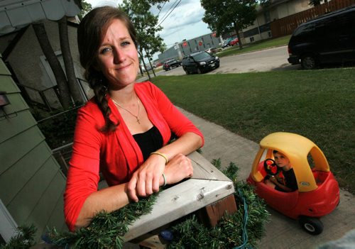 Stephanie Smith poses on her stoop while her son Ashton keeps an eye on things from his car.....See story re: Folk Festival Security training. June 17, 2015 - (Phil Hossack / Winnipeg Free Press)