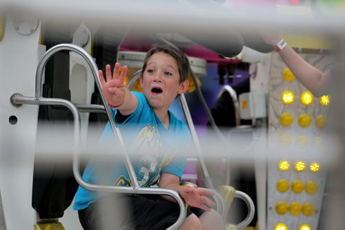 Eight-year-old Ryan Bremner flashes four fingers toward his dad as he gets ready to ride on the Remix Power ride with his brother Aidann (12yrs) for the forth time Wednesday evening despite the bad weather.  See story.   June 17, 2015 Ruth Bonneville / Winnipeg Free Press