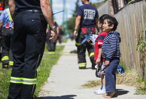 Children are evacuated from a fire at a day home at 703 Burrows Avenue in Winnipeg on Thursday, June 18, 2015.  Nobody appeared to be injured. Mikaela MacKenzie / Winnipeg Free Press