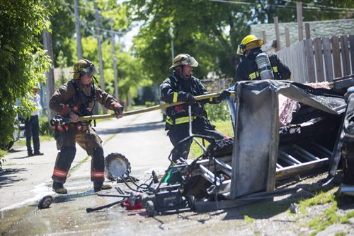 Firefighters haul a hose out to the back at a garage fire at 703 Burrows Avenue in Winnipeg on Thursday, June 18, 2015.  Nobody appeared to be injured, but children in a day home were evacuated. Mikaela MacKenzie / Winnipeg Free Press