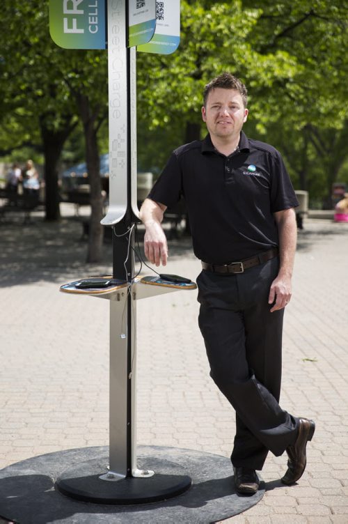 Justin Phillips, president and co-founder of Sycamore Inc, stand in front of one of their mobile solar cell phone charging station installation in Winnipeg on Thursday, June 18, 2015.  This station at the Forks is the first of its kind in Canada. Mikaela MacKenzie / Winnipeg Free Press