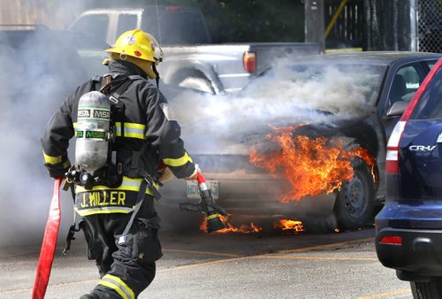 Winnipeg Fire Fighters arrive at the parking lot of the Superstore on McPhillips St. Thursday afternoon to extinguish a burning four door sedan. No one was injured but a vehicle parked nearby was also damaged. Wayne Glowacki / Winnipeg Free Press June 18  2015