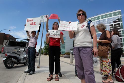 Protestors hold signs outside the Canadian Blood Service Agency in protest to the restrictions placed on homosexuals to be able to give blood Saturday.  June 20 & 21, 2015 Ruth Bonneville / Winnipeg Free Press