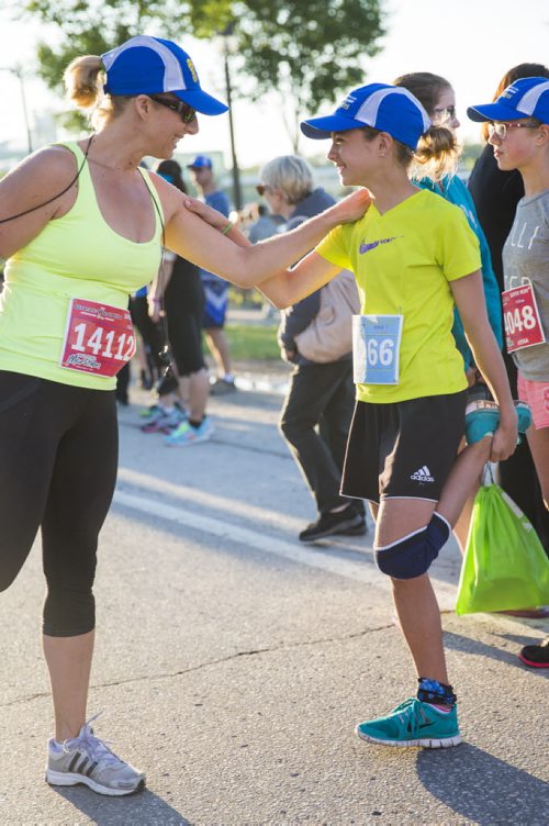 Tammy Beaudry and her daughter, Sophie, balance on each other while stretching in preparation for their first run together at the Manitoba Marathon at the University of Manitoba in Winnipeg on Sunday, June 21, 2015.  Mikaela MacKenzie / Winnipeg Free Press