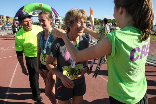 Sandi Atkinson receives her medal for finishing the half Manitoba Marathon Sunday morning. 150621 - Sunday, June 21, 2015 -  MIKE DEAL / WINNIPEG FREE PRESS