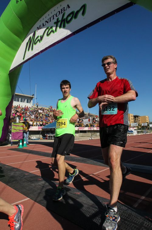 Participants in the Manitoba Marathon approach the finish line inside the University of Manitoba stadium Sunday morning. 150621 - Sunday, June 21, 2015 -  MIKE DEAL / WINNIPEG FREE PRESS