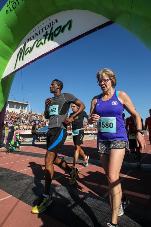 Participants in the Manitoba Marathon approach the finish line inside the University of Manitoba stadium Sunday morning. 150621 - Sunday, June 21, 2015 -  MIKE DEAL / WINNIPEG FREE PRESS