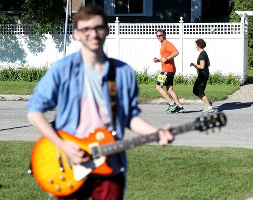 A member of The Minority plays music as runners head towards the BDI Bridge. Participants in the Manitoba Marathon, Sunday, June 21, 2015. (TREVOR HAGAN/WINNIPEG FREE PRESS)