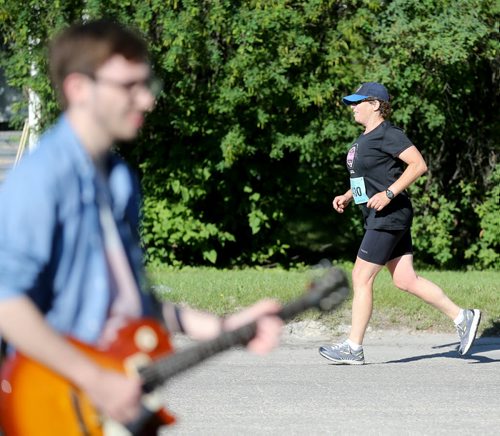 A member of The Minority plays music as a runner heads towards the BDI Bridge. Participants in the Manitoba Marathon, Sunday, June 21, 2015. (TREVOR HAGAN/WINNIPEG FREE PRESS)