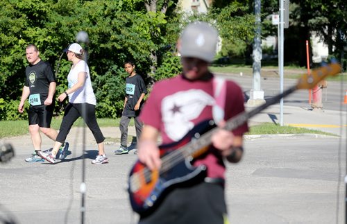 A member of The Minority plays music as runners head towards the BDI Bridge. Participants in the Manitoba Marathon, Sunday, June 21, 2015. (TREVOR HAGAN/WINNIPEG FREE PRESS)