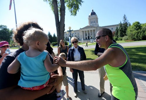 Robert Davey, right, stops and greets his granddaughter, Haven, 1, near the Legislative Building on Broadway. Participants in the Manitoba Marathon, Sunday, June 21, 2015. (TREVOR HAGAN/WINNIPEG FREE PRESS)