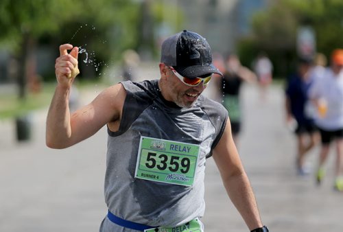 A runner hydrates on Lyndale Drive. Participants in the Manitoba Marathon, Sunday, June 21, 2015. (TREVOR HAGAN/WINNIPEG FREE PRESS)