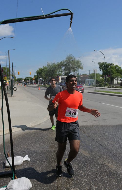A runner hyrates on St.Mary's Road. Participants in the Manitoba Marathon, Sunday, June 21, 2015. (TREVOR HAGAN/WINNIPEG FREE PRESS)