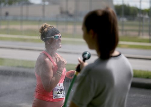 Kendra Hamin, 14, sprays runners on Dunkirk Drive. Participants in the Manitoba Marathon, Sunday, June 21, 2015. (TREVOR HAGAN/WINNIPEG FREE PRESS)