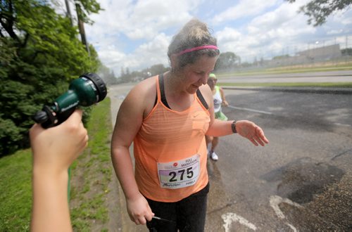 Kendra Hamin, 14, sprays runners on Dunkirk Drive. Participants in the Manitoba Marathon, Sunday, June 21, 2015. (TREVOR HAGAN/WINNIPEG FREE PRESS)