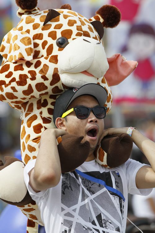 June 21, 2015 - 150621  -  A little tiring carrying around that stuffed giraffe at the Red River Ex in Winnipeg Sunday, June 21, 2015. John Woods / Winnipeg Free Press