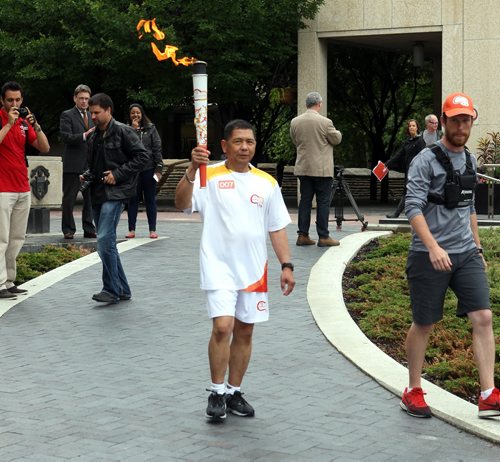 Delfin Tan is the first person that got to run with the torch from the Pan Am Games torch run. He started at City Hall in Winnipeg. BORIS MINKEVICH/WINNIPEG FREE PRESS June 22, 2015