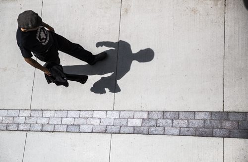 A pedestrian is preceded by his shadow in downtown Winnipeg on Monday, June 22, 2015. Mikaela MacKenzie / Winnipeg Free Press