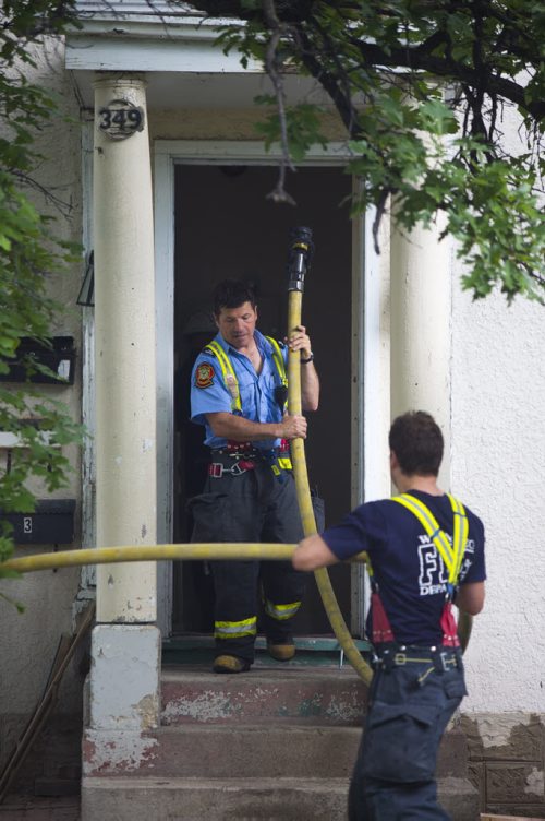 Firefighters haul a hose out of the house at a fire at 349 Bertrand street in Winnipeg on Tuesday, June 23, 2015. Mikaela MacKenzie / Winnipeg Free Press