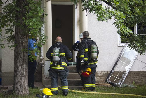 Firefighters stand outside a house fire at 349 Bertrand St. in Winnipeg on Tuesday, June 23, 2015. Mikaela MacKenzie / Winnipeg Free Press