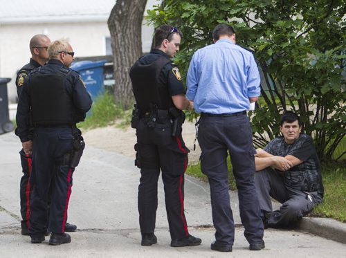 Police speak to a resident at a house fire at 349 Bertrand St. in Winnipeg on Tuesday, June 23, 2015. Mikaela MacKenzie / Winnipeg Free Press