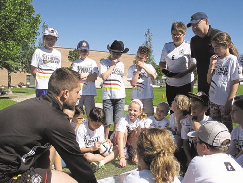 Canstar Community News June 18, 2015 - Oliver Fiest (left), a visiting Auf Ballhohe soccer coach from Munich, Germany, quizzes a group of Grade 4 German Bilingual program students at Princess Margaret School. (SHELDON BIRNIE/CANSTAR COMMUNITY NEWS/THE HERALD)