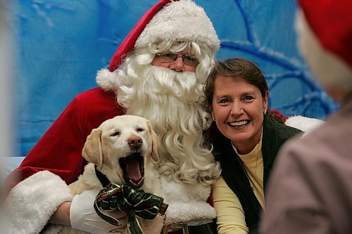 BORIS MINKEVICH / WINNIPEG FREE PRESS  071118 Santa, played here by Doug Speirs, poses with 12  year old yellow lab Cedar and her  owner Lois Melville. The photographer with his back facing the camera is Frank Adam.