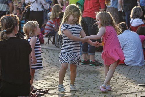 Maeve Thomas (left), 1, watches her sister, Gwen, 3, and friend Violet Funk (right), 4, dance in front of the Festival Stage at The Forks during the United Way 50th Anniversary concert, One Night For Winnipeg.  150624 June 24, 2015 MIKE DEAL / WINNIPEG FREE PRESS
