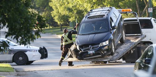 A tow truck operator removes a vehicle after it collided with a tree on  McIvor Ave. at Rothesay St. Thursday morning. No information on any posible injuries. Wayne Glowacki / Winnipeg Free Press June 25  2015