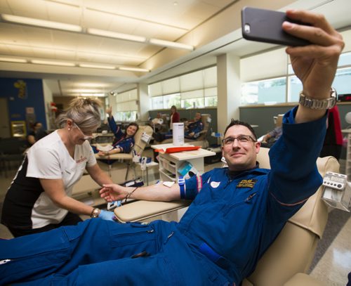 STARS flight paramedic Grant Therrien takes a selfie while giving blood as part of the Sirens for Life initiative at the Canadian Blood Services in Winnipeg on Thursday, June 25, 2015. Mikaela MacKenzie / Winnipeg Free Press